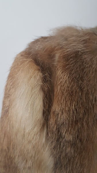 Close up of Vintage late 1980s to early 1990s brown rabbit fur jacket on a mannequin, showing the small area of fur loss or thinning at one shoulder, which is subtle and not immediately noticeable when worn. The wear may be consistent with friction from a shoulder bag, although the cause cannot be confirmed - back view