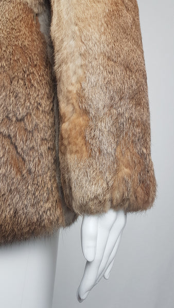 Close-up of a vintage late 1980s to early 1990s brown rabbit fur jacket on a mannequin, showing the sleeve and natural tonal variations - front view