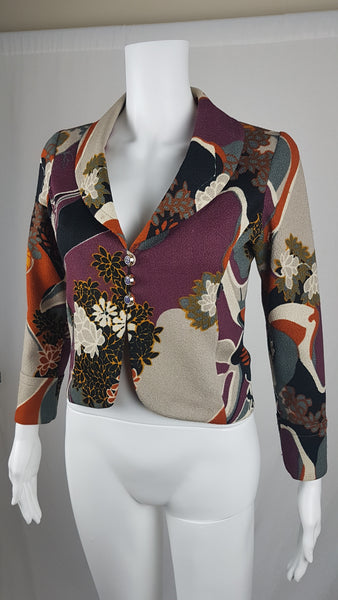 Vintage Y2K cropped jacket displayed on a mannequin, featuring three-quarter sleeves and an abstract floral print in plum, rust, cream, black and grey - front view