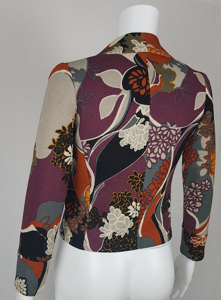 Vintage Y2K cropped jacket displayed on a mannequin, featuring three-quarter sleeves and an abstract floral print in plum, rust, cream, black and grey - back view