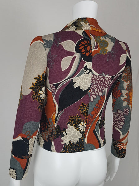 Vintage Y2K cropped jacket displayed on a mannequin, featuring three-quarter sleeves and an abstract floral print in plum, rust, cream, black and grey - back view