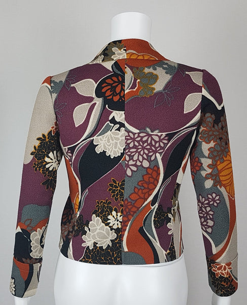 Vintage Y2K cropped jacket displayed on a mannequin, featuring three-quarter sleeves and an abstract floral print in plum, rust, cream, black and grey - back view
