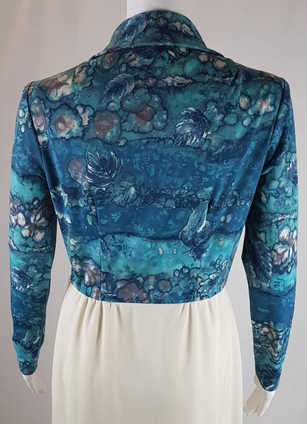 Back view of Vintage 1970s Missy House of Canada maxi dress with an aqua blue patterned bodice, long sleeves, pointed collar, and a white skirt with coordinating abstract panels shown on a mannequin