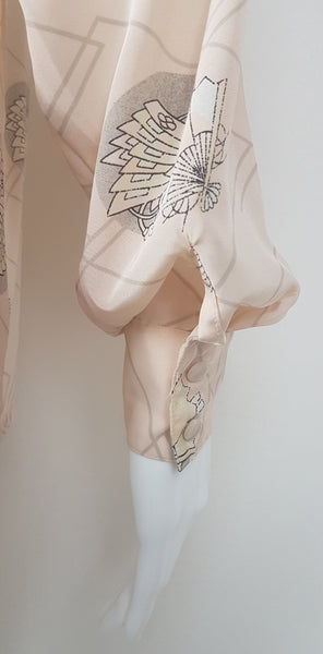 Sleeve and cuff detail of Vintage 1980s pastel peach Jac Dale shirt with long sleeves, a pointed collar, and an abstract grey fan print on a mannequin