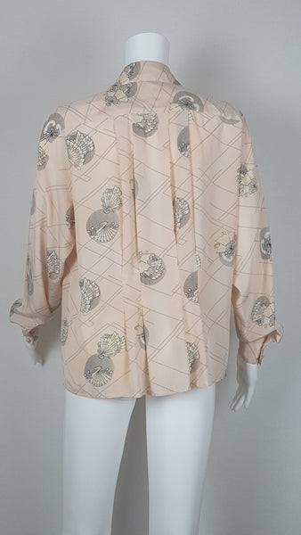Vintage 1980s pastel peach Jac Dale shirt with long sleeves, a pointed collar, and an abstract grey fan print on a mannequin