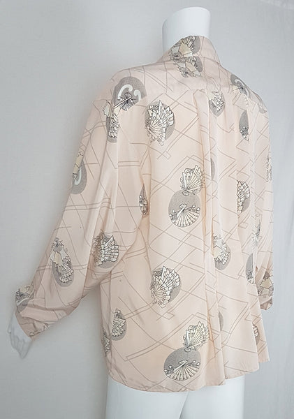 Vintage 1980s pastel peach Jac Dale shirt with long sleeves, a pointed collar, and an abstract grey fan print on a mannequin