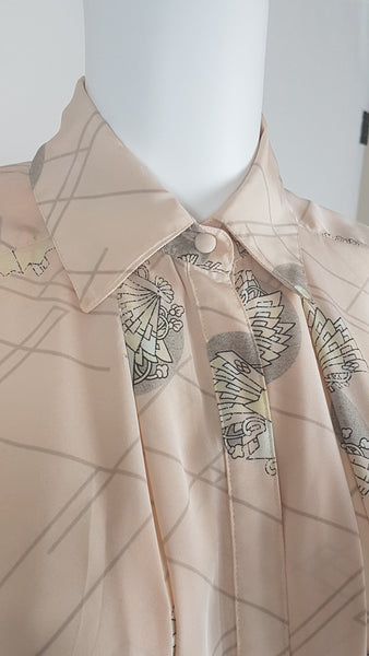 Vintage 1980s pastel peach Jac Dale shirt with long sleeves, a pointed collar, and an abstract grey fan print on a mannequin