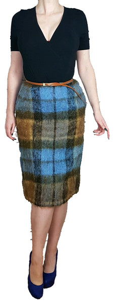 Woman wearing a black v-neck short sleeve top, and a Vintage 1970s Andrew Stewart mohair and wool pencil skirt with a fuzzy plaid pattern in blue, brown, grey, and olive 